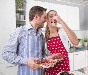Verliebtes junges Paar in der Küche beim Essen